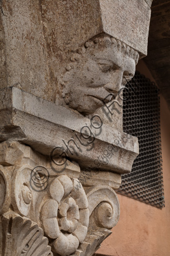 Modena, Ghirlandina Tower, Torresani Hall, north wall: a Corinthian capital with a sculpted face in the abacus protome. Campionese Masters, XII - XIII century.