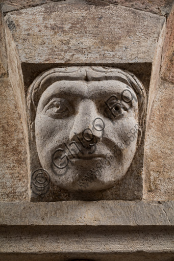 Modena, torre Ghirlandina, sala dei Torresani, parete nord: capitello corinzio con un viso scolpito nella protome dell'abaco. Maestri campionesi, XII - XIII secolo. Particolare.