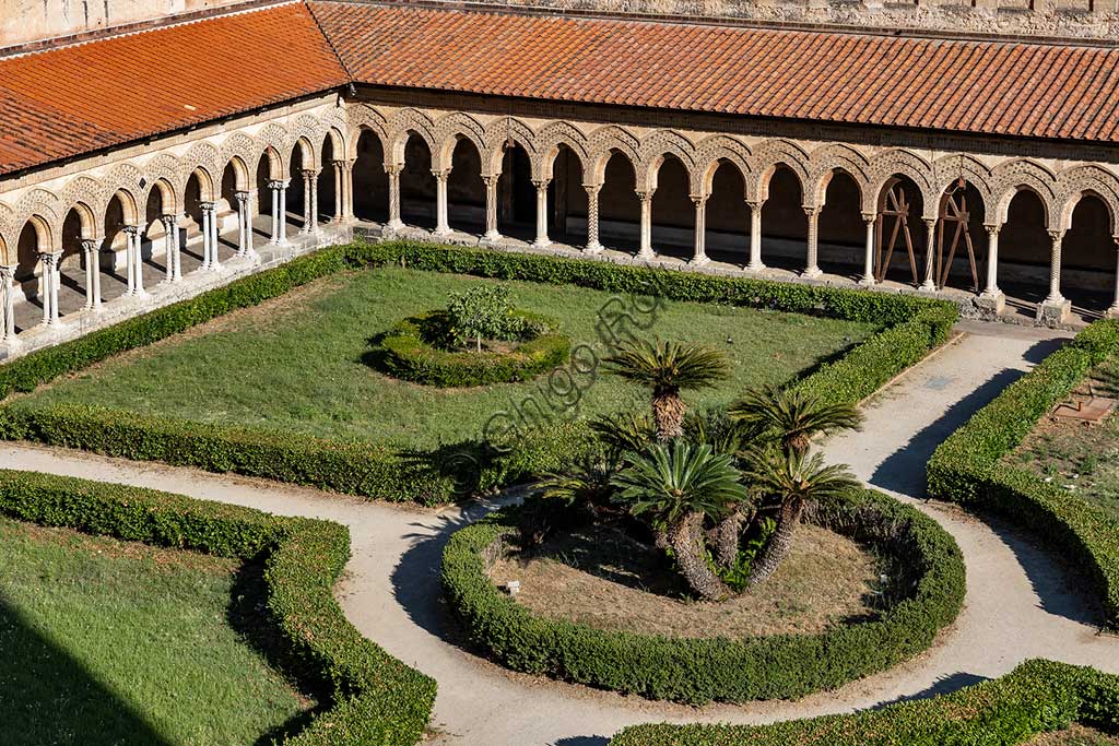 Monreale, Duomo, chiostro del monastero benedettino: scorcio del chiostro (XII sec.) con colonnati di archi e aiuole con palme.