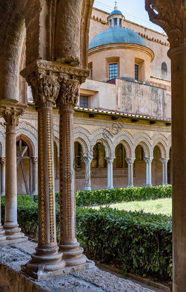 Monreale, Duomo, chiostro del monastero benedettino (XII secolo):il capitello W20, faccia Sud; "I figli di Noè al lavoro nella vigna e Noè che torchia l'uva." Sullo sfondo, il fianco meridionale della Cattedrale.