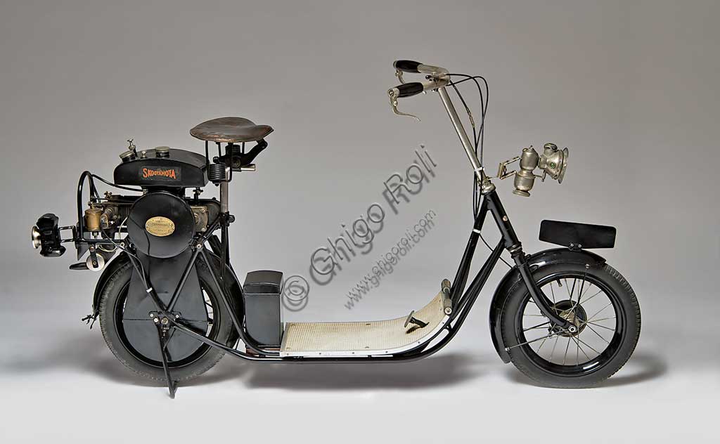 Moto d'epoca ABC Skootamota. Scooter.Marca: ABC - Gilbert Campling Ltdmodello: Skootamotanazione: Regno Unito - Londraanno: 1919condizioni: restauratocilindrata: 125 cc, 1 Hpmotore: quattro tempi a cilindro orizzontale e valvole contrapposte (aspirazione laterale, scarico in testa)Questo scooter da un cavallo di potenza fu disegnato da Granville Bradshaw e fu uno degli scooter migliori e più diffusi. Il motore era montato direttamente sopra la ruota posteriore e trasmetteva il moto in presa diretta tramite catena. Una delle caratteristiche che lo fecero più apprezzare fu la comoda sella.