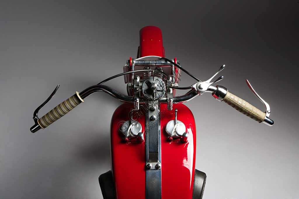 Moto d'epoca Benelli 175 Bialbero CorsaMarca: Benellimodello: 175 Bialbero Corsanazione: Italia - Pesaroanno: 1934condizioni: restauratacilindrata: 172,1 (alesaggio e corsa 62 x 57)motore: monocilindrico, a due alberi a cammes in testacambio: a  4 rapportiDopo aver prodotto le prime motoleggere turistiche, i Fratelli Benelli sentirono ben presto (già dal '27) l'esigenza di cimentarsi con le moto da corsa, dando così inizio ad una lunga stagione di successi. La 175 Bialbero Corsa, un'evoluzione della Gran Sport di serie, esordì nel '27 e, condotta da Tonino Benelli, vinse quasi tutte le gare più importanti di quell'anno aggiudicandosi il campionato italiano, oltre ad alcuni record mondiali. Raggiungeva i 150 km/h. Questo esemplare, dei soli sei o sette prodotti, appartenne al grande pilota pesarese Dorino Serafini, che fu campione italiano nel '33 e nel '36 (classe 500) e corse, con la Ferrari, la Mille Miglia del '50 e del '51.