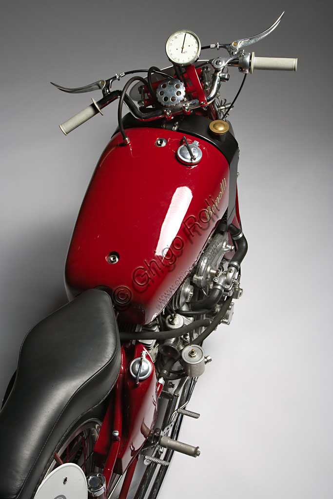 Moto d'epoca Benelli 250 Corsa 4 Cilindri con CompressoreMarca: Benellimodello: 250 Corsa 4 Cilindri con Compressorenazione: Italia - Pesaroanno: 1942condizioni: restauratacilindrata: 248,2 (alesaggio e corsa 41 x 47)motore: quattro cilindri con compressorecambio: in blocco a quattro rapportiAnche la forma del manubrio, che ricorda le corna di un toro, sembra voler sottolineare la potenza, realmente mostruosa per i tempi, di questa Benelli da competizione. Grazie a un compressore Cozette, azionato da ingranaggi innestati sul cambio, la 250 quattro cilindri sprigionava 55,2 Hp a 13.000 giri e, a dispetto della cilindrata di soli 250 cc, raggiungeva i 230 km/h. Concepita nel '39 fu prodotta in pochissimi esemplari di cui questo sembra l'unico superstite. A causa della guerra non partecipò a nessuna competizione e rimane uno degli esempi più alti delle capacità tecniche dell'industria motociclistica di quell'epoca.