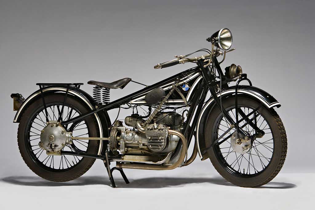 Moto d'epoca BMW R 42Marca: Bayerische Motoren Werkemodello: R 42nazione: Germania - Monacoanno: 1927condizioni:  restauratacilindrata: 500 cc.  motore: boxercambio: in blocco a tre rapportiCostretta dal Trattato di pace di Versailles a cessare la produzione di motori per aerei (di cui rimane traccia nell'elica stilizzata del marchio), la fabbrica bavarese, nel 1919 si orienta definitivamente alla produzione di motociclette. Intorno al primo motore boxer (a due cilindri contrapposti) progettato da Martin Stolle, il brillante Max Friz, proveniente dalla Mercedes, costruisce la prima motocicletta di una serie che dura ancor oggi con le stesse eleganti caratteristiche progettuali di base: motore boxer, albero motore disposto longitudinalmente che si prolunga nel cambio in blocco e nella trasmissione finale ad albero. E' la R 32 del 1923. Prodotta in 3095 esemplari costava 2200 marchi ed era la moto più cara al mondo. Questa rara R 42 ne è il logico sviluppo, quattro anni dopo.