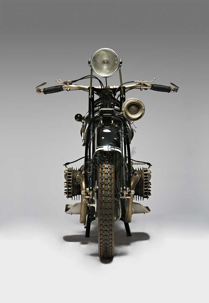 Moto d'epoca BMW R 42Marca: Bayerische Motoren Werkemodello: R 42nazione: Germania - Monacoanno: 1927condizioni:  restauratacilindrata: 500 cc.  motore: boxercambio: in blocco a tre rapportiCostretta dal Trattato di pace di Versailles a cessare la produzione di motori per aerei (di cui rimane traccia nell'elica stilizzata del marchio), la fabbrica bavarese, nel 1919 si orienta definitivamente alla produzione di motociclette. Intorno al primo motore boxer (a due cilindri contrapposti) progettato da Martin Stolle, il brillante Max Friz, proveniente dalla Mercedes, costruisce la prima motocicletta di una serie che dura ancor oggi con le stesse eleganti caratteristiche progettuali di base: motore boxer, albero motore disposto longitudinalmente che si prolunga nel cambio in blocco e nella trasmissione finale ad albero. E' la R 32 del 1923. Prodotta in 3095 esemplari costava 2200 marchi ed era la moto più cara al mondo. Questa rara R 42 ne è il logico sviluppo, quattro anni dopo.