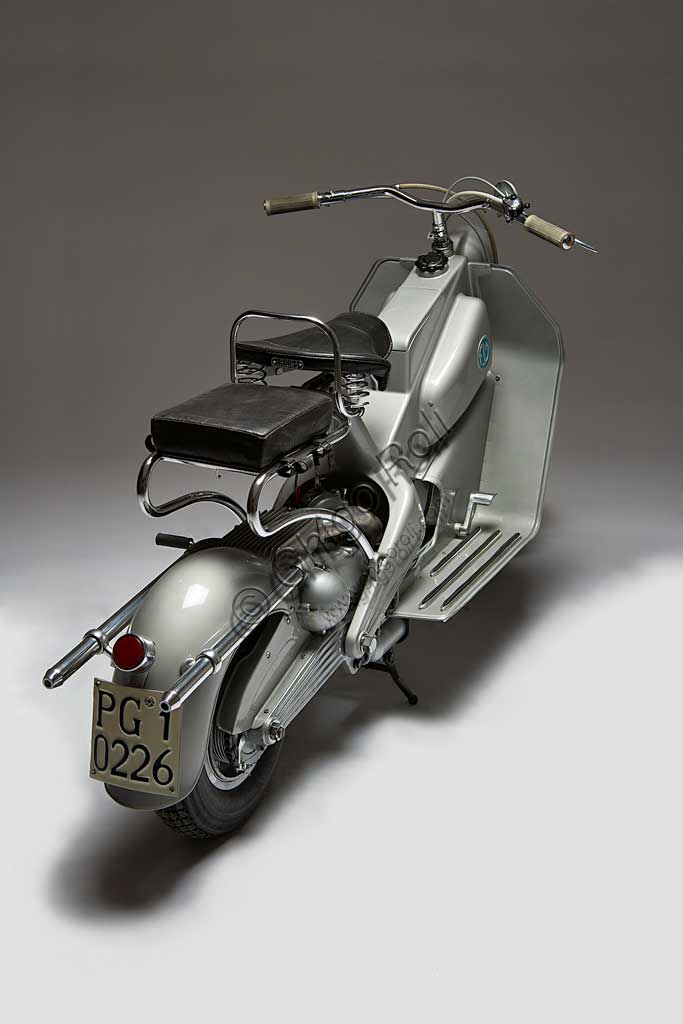 Moto d'epoca FM Scooter.Marca: F.M. Fratelli Moltenimodello: Scooternazione: Italia - Milanoanno: 1950condizioni: restauratocilindrata: 125 cc.motore: monocilindrico a due tempicambio: al manubrio a tre rapportiQuesto scooter milanese dalle soluzioni tecniche raffinatissime fu prodotto solo dal '50 al '52 e in pochi esemplari; forse era troppo avanti per piacere, forse costava troppo.Ha un bellissimo telaio-scocca in fusione d'alluminio che comprende, in un unico pezzo,  fanale, serbatoio, vano portaoggetti, cannotto della sella e forcellone sdoppiato con attacchi per il motore e le sospensioni posteriori.Anche la marmitta è un piccolo capolavoro di design industriale, degna forse più di una moto importante che di uno scooter: ha camera di espansione alettata in fusione di alluminio e doppio tubo di scarico cromato.