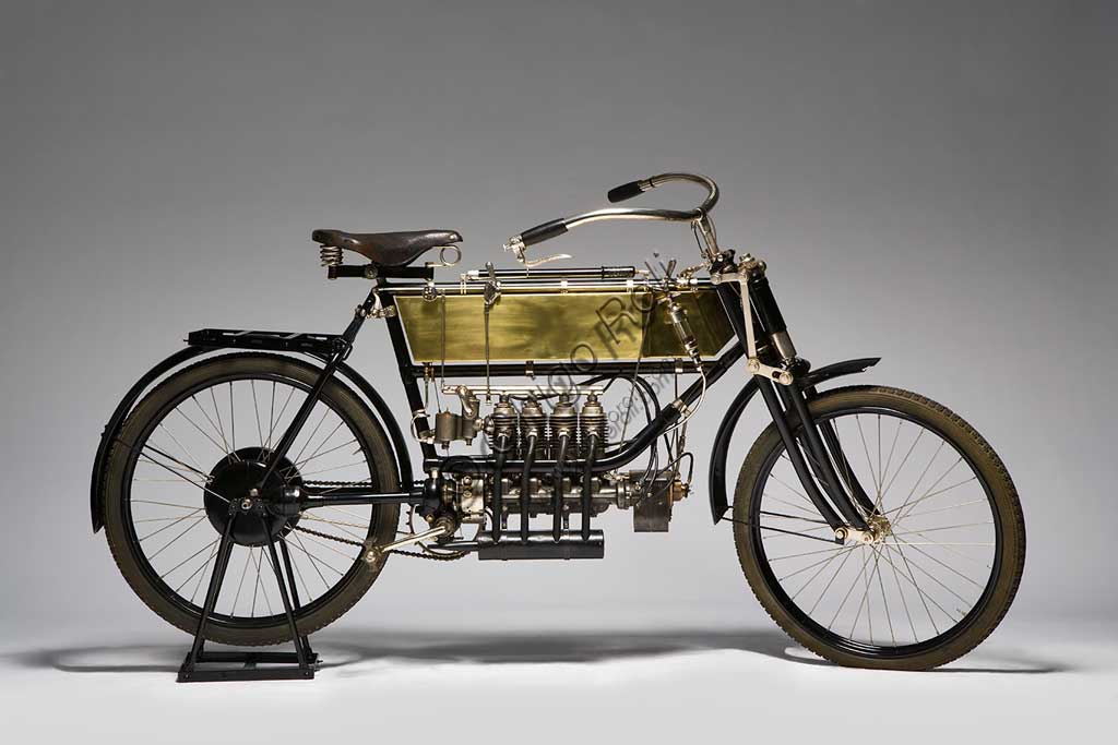 Moto d'epoca FN Quattro Cilindrifabbrica: FNmodello: quattro cilindri fabbricata in: Belgio - Herstalanno di costruzione: 1905condizioni: restauratacilindrata: 362 cc (alesaggio e corsa: 45 x 57)motore: quattro cilindri in lineatrasmissione:ad albero e giunti cardaniciLa Fn, nata come fabbrica di armi nel 1870, e conosciuta oggi come Herstal, è ancora uno dei maggiori pratagonisti a livello mondiale del settore  con i marchi  Winchester e Browning. Nel 1901 iniziò la produzione di motociclette, che divennero ben presto famose per la loro grande affidabilità e ottennero successi di pubblico e importanti commesse militari. Nel 1904 la produzione toccò le seimila unità.Questo modello, elegantissimo nelle sue curve ancora di bicicletta e nei bagliori dorati del suo serbatoio di ottone, sfoggia alcune soluzioni di assoluta avanguardia:  motore quattro cilindri in linea con valvole di aspirazione automatiche a depressione, trasmissione ad albero e giunti cardanici, forcella elastica a doppio effetto con biscottini oscillanti.