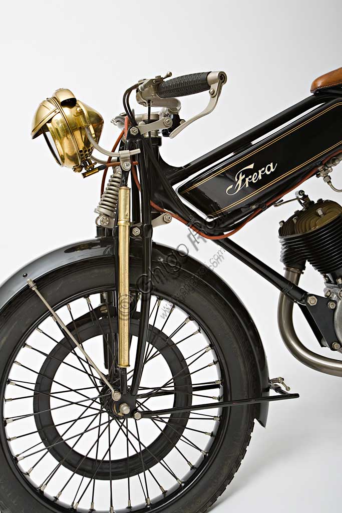 Moto d'epoca Frera SK 350 SportMarca: Freramodello: SK 350 Sportnazione: Italia - Milano, Tradateanno: 1925condizioni: restauratacilindrata: 348,2 cc (alesaggio e corsa 71 x 88)motore: monocilindrico a valvole lateralicambio: a tre rapportiNella produzione  Frera  i modelli SK si collocano tra i più tranquilli Turismo e i modelli SK Super Sport a valvole in testa. Vengono utilizzati anche nelle corse arrivando spesso nei primi posti. Veniva venduta normalmente senza fanale ma il tipo Sport qui illustrato, con freni anteriore e posteriore a cerchietto, monta un raro impianto di illuminazione a gas, fornito come accessorio a parte, la cui bombola è montata sullo stelo anteriore destro della forcella, mentre su quello sinistro si nota la pompa per gonfiare le gomme.