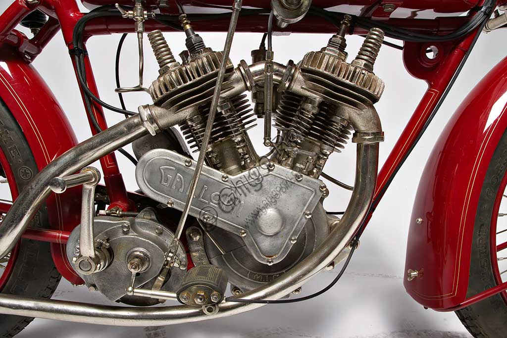 Moto d'epoca Galloni 750 SS. Motore.fabbrica: MG - Moto Gallonimodello: 750 SS fabbricata in: Italia - Borgomaneroanno di costruzione: 1920-21condizioni: restauratacilindrata: 744 cc (alesaggio e corsa: 76 x 82)motore: bicilindrico a V, a valvole lateralicambio:a mano a tre rapportiAlberto Galloni, titolare della MG di Borgomanero, costruisce la sua prima moto da corsa nel 1919. In sella a questa bicilindrica il pilota Miro Maffeis si aggiudica alcuni record mondiali. L'anno successivo inizia la produzione di serie con una due tempi ed una 500 quattro tempi bicilindrica. La fabbrica rimarrà attiva fino al 1932, creando una decina di modelli, alcuni dei quali  raccolsero diversi successi in campo sportivo con i piloti Augusto Rava e Alfredo Panella. L'esemplare qui mostrato divide con un'altra moto simile di 500 cc, l'onore di essere l'unica superstite nota di tutta la produzione. Elegante nelle forme e nelle soluzioni tecniche, ha cilindri e teste nichelati, tappi delle teste interamente alettati, serbatoio a due scomparti con dosatore regolabile, forcella elastica brevettata a due molle in compressione. Monta un freno a tamburo sulla ruota posteriore.