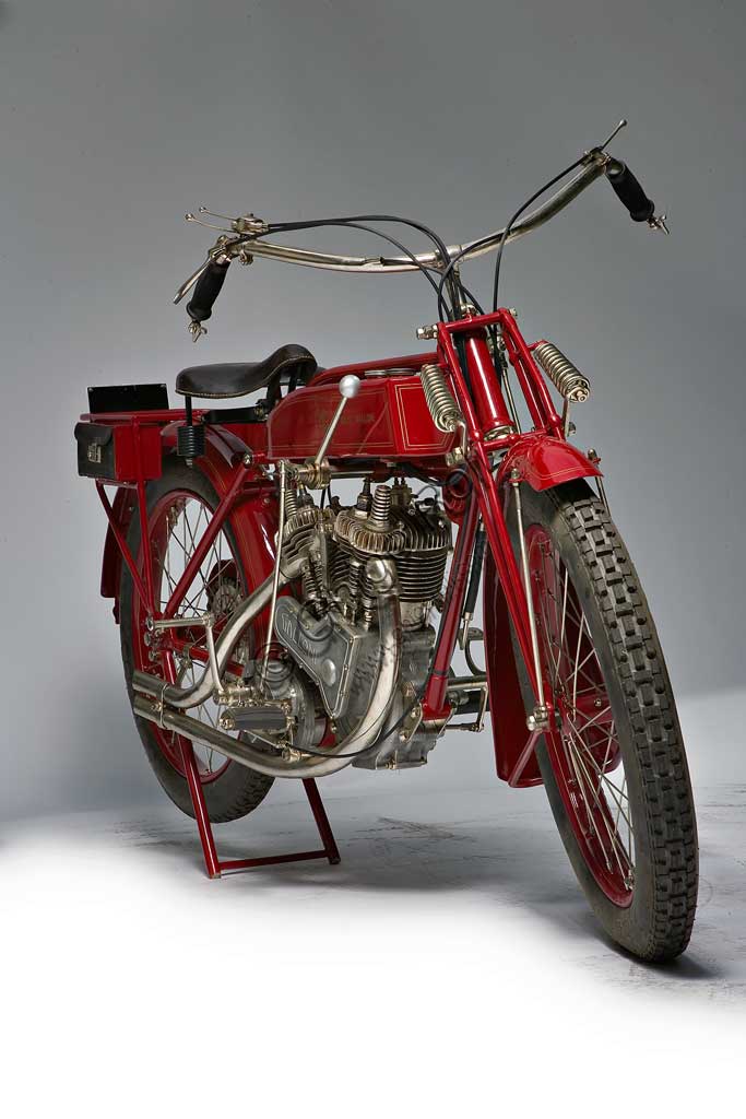 Moto d'epoca Galloni 750 SSfabbrica: MG - Moto Gallonimodello: 750 SS fabbricata in: Italia - Borgomaneroanno di costruzione: 1920-21condizioni: restauratacilindrata: 744 cc (alesaggio e corsa: 76 x 82)motore: bicilindrico a V, a valvole lateralicambio:a mano a tre rapportiAlberto Galloni, titolare della MG di Borgomanero, costruisce la sua prima moto da corsa nel 1919. In sella a questa bicilindrica il pilota Miro Maffeis si aggiudica alcuni record mondiali. L'anno successivo inizia la produzione di serie con una due tempi ed una 500 quattro tempi bicilindrica. La fabbrica rimarrà attiva fino al 1932, creando una decina di modelli, alcuni dei quali  raccolsero diversi successi in campo sportivo con i piloti Augusto Rava e Alfredo Panella. L'esemplare qui mostrato divide con un'altra moto simile di 500 cc, l'onore di essere l'unica superstite nota di tutta la produzione. Elegante nelle forme e nelle soluzioni tecniche, ha cilindri e teste nichelati, tappi delle teste interamente alettati, serbatoio a due scomparti con dosatore regolabile, forcella elastica brevettata a due molle in compressione. Monta un freno a tamburo sulla ruota posteriore.