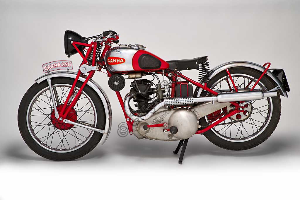 Moto d'epoca Ganna 250 cc.Marca: Gannamodello: 250ccnazione: Italia - Vareseanno: 1935condizioni: restauratacilindrata: 249 (alesaggio e corsa 62,5 x 81)motore: Rudge Python monocilindrico a 4 valvole in testa e doppio tubo di scaricocambio: Python a quattro rapporti, a pedaleLuigi Ganna fu ciclista e grande campione, battendo il record dell'ora nel 1908 con 40,405 km e vincendo, tra il resto, il giro d'Italia 1909. Iniziò a costruire biciclette già nel 1911, mentre ancora correva. Diede vita a una regolare produzione di motociclette nel 1923 montando motori Jap e Blackburne sui propri telai.Questa 250 del '35 monta un potente motore Python a quattro valvole della affermata Rudge che le consentiva di raggiungere i 110 km/h.Nel catalogo dell'epoca si legge:"Prezzo  Lire 4450. Supplemento di Lire 75 per il comando del cambio a pedale, e di Lire 275 per il pannello strumenti incorporato nel serbatoio". Nello stesso anno ritirerà dal catalogo questo modello per produrne uno con motorizzazione propria.