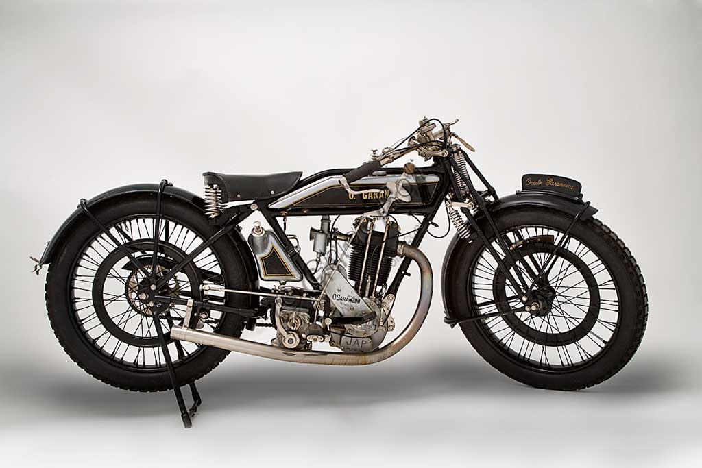 Moto d'epoca Garanzini 350 HP 3Marca: Oreste Garanzinimodello: HP 3 - 350nazione: Italia - Milanoanno: 1925condizioni: restauratacilindrata: 346 cc (alesaggio e corsa 70 x 90)motore: monocilindrico Japcambio: Sturmey e Archer  a tre rapportiOreste Garanzini, milanese, fu pilota di valore oltre che tecnico valente. Nel 1921 vinse il Campionato Italiano classe 350 in sella all'inglese Verus. Nel 1922 diede vita alla sua casa: la Jap - Garanzini, che poi diverrà solo Oreste Garanzini.Produsse motociclette raffinatissime fino al 1931, quando cessò l'attività per dedicarsi al commercio di autovetture.Questo bellissimo esemplare rivela nei dettagli la cura costruttiva: serbatoi della benzina e dell'olio in fusione di alluminio, freni a cerchietto su entrambe le ruote, pompa dell'olio con dosatore a vista, forcella brevettata a parallelogramma con doppia molla in compressione e doppia molla in estensione.