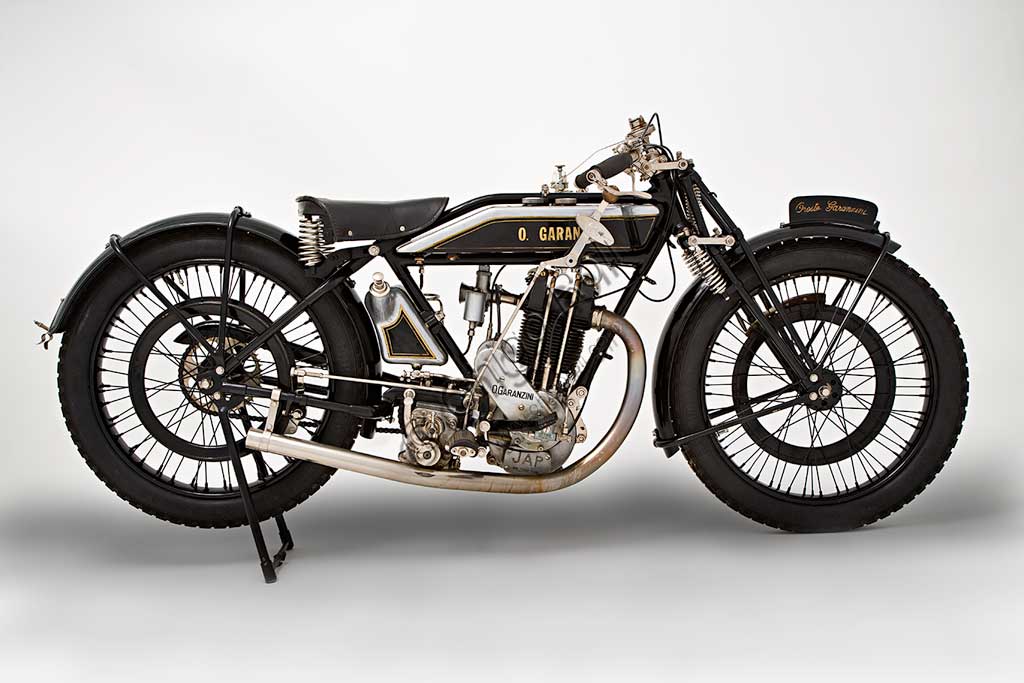 Moto d'epoca Garanzini 350 HP 3Marca: Oreste Garanzinimodello: HP 3 - 350nazione: Italia - Milanoanno: 1925condizioni: restauratacilindrata: 346 cc (alesaggio e corsa 70 x 90)motore: monocilindrico Japcambio: Sturmey e Archer  a tre rapportiOreste Garanzini, milanese, fu pilota di valore oltre che tecnico valente. Nel 1921 vinse il Campionato Italiano classe 350 in sella all'inglese Verus. Nel 1922 diede vita alla sua casa: la Jap - Garanzini, che poi diverrà solo Oreste Garanzini.Produsse motociclette raffinatissime fino al 1931, quando cessò l'attività per dedicarsi al commercio di autovetture.Questo bellissimo esemplare rivela nei dettagli la cura costruttiva: serbatoi della benzina e dell'olio in fusione di alluminio, freni a cerchietto su entrambe le ruote, pompa dell'olio con dosatore a vista, forcella brevettata a parallelogramma con doppia molla in compressione e doppia molla in estensione.