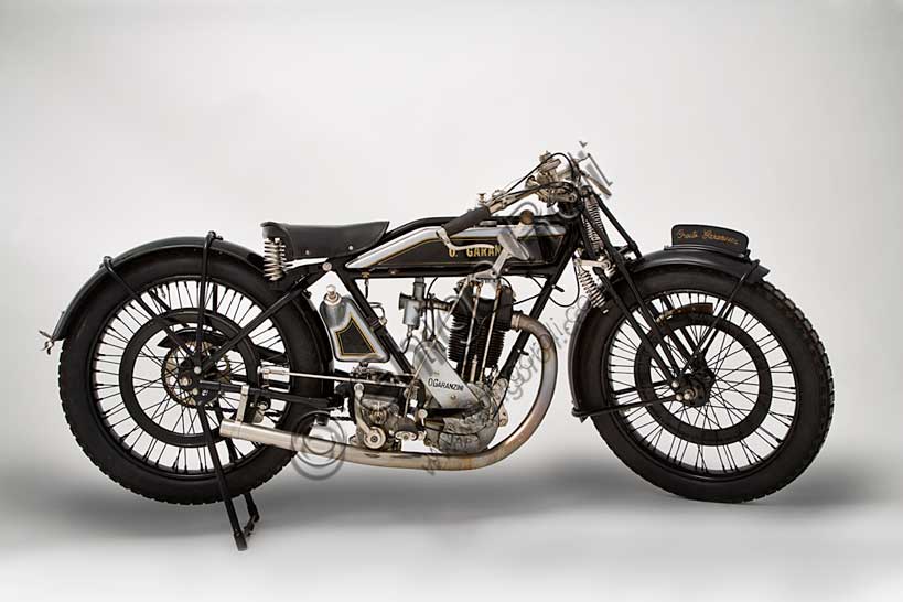 Moto d'epoca “Garanzini 350 HP 3”Marca: Oreste Garanzinimodello: HP 3 - 350nazione: Italia - Milanoanno: 1925condizioni: restauratacilindrata: 346 cc (alesaggio e corsa 70 x 90)motore: monocilindrico Japcambio: Sturmey e Archer  a tre rapportiOreste Garanzini, milanese, fu pilota di valore oltre che tecnico valente. Nel 1921 vinse il Campionato Italiano classe 350 in sella all'inglese Verus. Nel 1922 diede vita alla sua casa: la Jap - Garanzini, che poi diverrà solo Oreste Garanzini.Produsse motociclette raffinatissime fino al 1931, quando cessò l'attività per dedicarsi al commercio di autovetture.Questo bellissimo esemplare rivela nei dettagli la cura costruttiva: serbatoi della benzina e dell'olio in fusione di alluminio, freni a cerchietto su entrambe le ruote, pompa dell'olio con dosatore a vista, forcella brevettata a parallelogramma con doppia molla in compressione e doppia molla in estensione.