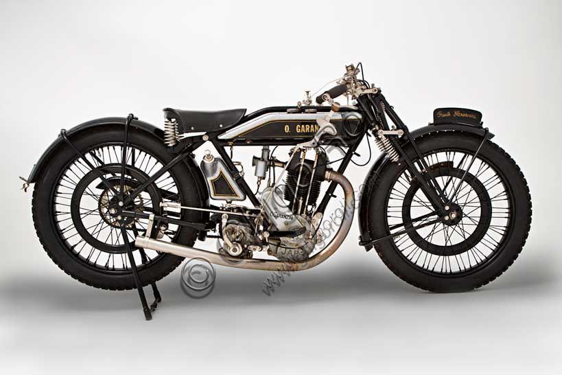 Moto d'epoca “Garanzini 350 HP 3”Marca: Oreste Garanzinimodello: HP 3 - 350nazione: Italia - Milanoanno: 1925condizioni: restauratacilindrata: 346 cc (alesaggio e corsa 70 x 90)motore: monocilindrico Japcambio: Sturmey e Archer  a tre rapportiOreste Garanzini, milanese, fu pilota di valore oltre che tecnico valente. Nel 1921 vinse il Campionato Italiano classe 350 in sella all'inglese Verus. Nel 1922 diede vita alla sua casa: la Jap - Garanzini, che poi diverrà solo Oreste Garanzini.Produsse motociclette raffinatissime fino al 1931, quando cessò l'attività per dedicarsi al commercio di autovetture.Questo bellissimo esemplare rivela nei dettagli la cura costruttiva: serbatoi della benzina e dell'olio in fusione di alluminio, freni a cerchietto su entrambe le ruote, pompa dell'olio con dosatore a vista, forcella brevettata a parallelogramma con doppia molla in compressione e doppia molla in estensione.