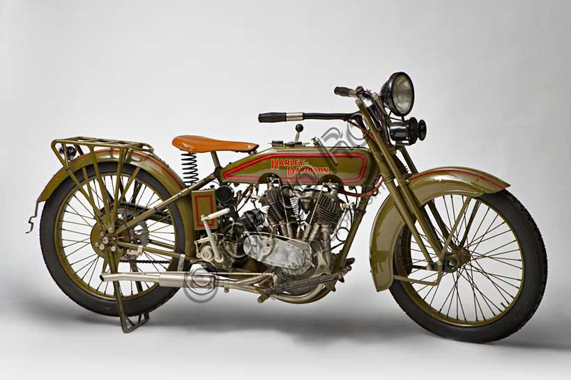 Moto d'epoca “Harley-Davidson 22 JD”Marca: Harley-Davidsonmodello: 22 JDnazione: U.S.A. - Milwaukeeanno: 1922condizioni: restauratacilindrata: 1213 (74 cubic inch)motore: Bicilindrico a V di 45°a valvole contrappostecambio: a tre rapportiGià dal 1920 la H-D, fondata nel 1903 da William Harley e Arthur Davidson, era divenuta la prima casa motociclistica al mondo, con rappresentanze in 67 paesi e 28.189 moto prodotte. Nello stesso anno il pilota Leslie "Red" Parkhurst aveva bruciato 23 record mondiali di velocità. Il 28 aprile 1921 fu una Harley a superare, prima al mondo, la velocità di 100 mph (160 km/h).Nel '22 il bicilindrico siglato JD viene portato a 74 pollici cubici di cilindrata (1213 cc.) e rimane il punto più alto dello sviluppo di questo tipo di motore a valvola di aspirazione in testa.