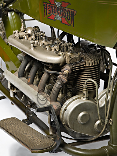 Moto d'epoca Henderson 1100 mod G.Marca: Henderson & Supply Co.modello: 1100 mod Gnazione: U.S.A. - Detroit / Chicagoanno: 1917condizioni: restauratacilindrata: 1068 (alesaggio e corsa motore: quattro cilindri in linea a valvole contrappostecambio: Il marchio Henderson è legato indissolubilmente al quattro cilindri più noto e amato degli U.S.A. Purtroppo, a causa di difficoltà economiche, la Henderson sarà acquisita già nel '17 dalla Excelsior che trasferirà gli stabilimenti a Chicago. Fu a bordo di una Henderson quattro cilindri che Carl Stearns Clancy di New York fece per primo il giro del mondo in moto (era il 1913 e questo la dice lunga sull'affidabilità di questa moto...). Caratteristiche particolari:  Ha forcella anteriore a ruota tirata, con biscottini inferiori e molle racchiusi in astucci tubolari. Ha valvole contrapposte con aspirazione in testa e scarico laterali, comandate da un unico asse a cammes sulla destra del basamento.Questo esemplare è la prima moto storica iscritta all'ASI e porta il numero di iscrizione 0001.