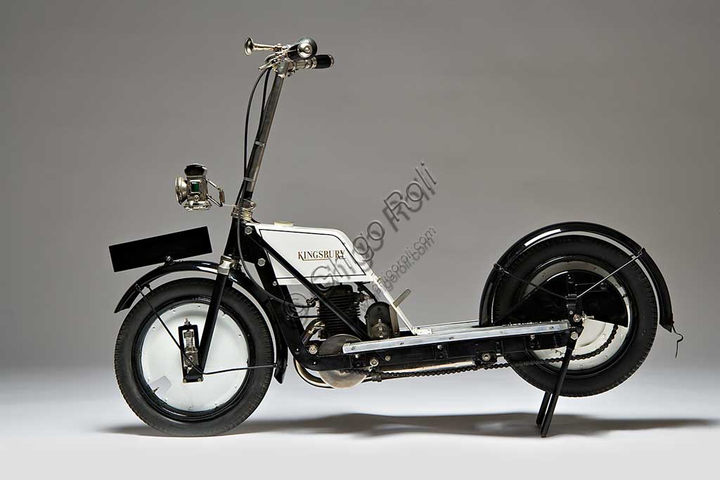 Moto d'epoca Kingsbury Scooter.Marca: Kingsbury Aviation Co.modello: Scooternazione: Regno Unito -Kingsbury, Londonanno: 1918condizioni: restauratocilindrata: 150 ccmotore: monocilindrico a due tempi cambio: Quando venne presentato, questo scooter inglese reclamizzava il disegno che, con motore protetto, ampio silenziatore sotto il pianale, carter della catena avvolgente, avrebbe garantito una assoluta pulizia del conducente. A quei tempi infatti, il problema maggiore per chi viaggiava in scooter, sembrava essere il far ritorno da ogni, sia pur breve, spostamento tutti imbrattati d'olio benzina e polvere della strada. Anche le piccole sospensioni a molla montate direttamente sul mozzo, tentavano di offrire un certo confort.Il motore a due tempi erogava una potenza di 2,5 Hp. Non sappiamo molto altro di questo scooter che evidentemente non ebbe grande diffusione. Oggi se ne conoscono solo tre esemplari superstiti.