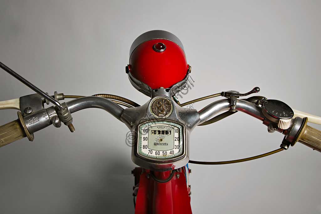 Moto d'epoca Lambretta  D Sport. Scooter.Marca: Innocentimodello: Lambretta D Sportnazione: Italia - Milanoanno: 1954condizioni: restauratacilindrata: 123 cc. (alesaggio e corsa 52 x 58)motore: monocilindrico a due tempicambio: a tre rapporti con comando al manubrioNei suoi primi anni di vita la Lambretta si cimentò anche nelle corse e lo fece con notevoli successi. Già nel 1951, con una Lambretta C, Ernesto Longoni coprì i 1340 chilometri della Milano-Taranto in 17 ore e 26 minuti, ovviamente vincendo nella sua categoria, alla media di 75,9 km/h; era una media  straordinaria se si pensa che la "C" di serie faceva al massimo i 90 km/h. Anche nel '53, Luigi Fumagalli con una "D" Sport del tutto simile a questa, vinse di nuovo la Milano-Taranto. Poi la Innocenti chiuderà definitivamente la stagione delle competizioni, un'attività decisamente lontana dalla filosofia della Lambretta, che pure aveva dimostrato una grandissima affidabilità.