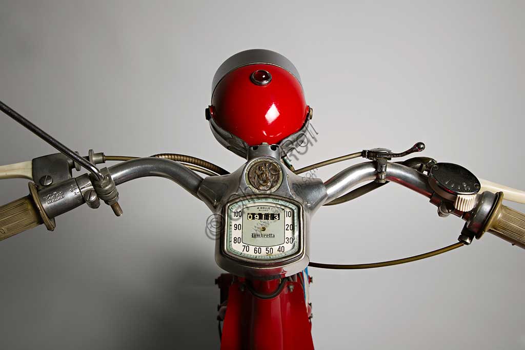 Moto d'epoca Lambretta  D Sport. Scooter.Marca: Innocentimodello: Lambretta D Sportnazione: Italia - Milanoanno: 1954condizioni: restauratacilindrata: 123 cc. (alesaggio e corsa 52 x 58)motore: monocilindrico a due tempicambio: a tre rapporti con comando al manubrioNei suoi primi anni di vita la Lambretta si cimentò anche nelle corse e lo fece con notevoli successi. Già nel 1951, con una Lambretta C, Ernesto Longoni coprì i 1340 chilometri della Milano-Taranto in 17 ore e 26 minuti, ovviamente vincendo nella sua categoria, alla media di 75,9 km/h; era una media  straordinaria se si pensa che la "C" di serie faceva al massimo i 90 km/h. Anche nel '53, Luigi Fumagalli con una "D" Sport del tutto simile a questa, vinse di nuovo la Milano-Taranto. Poi la Innocenti chiuderà definitivamente la stagione delle competizioni, un'attività decisamente lontana dalla filosofia della Lambretta, che pure aveva dimostrato una grandissima affidabilità.