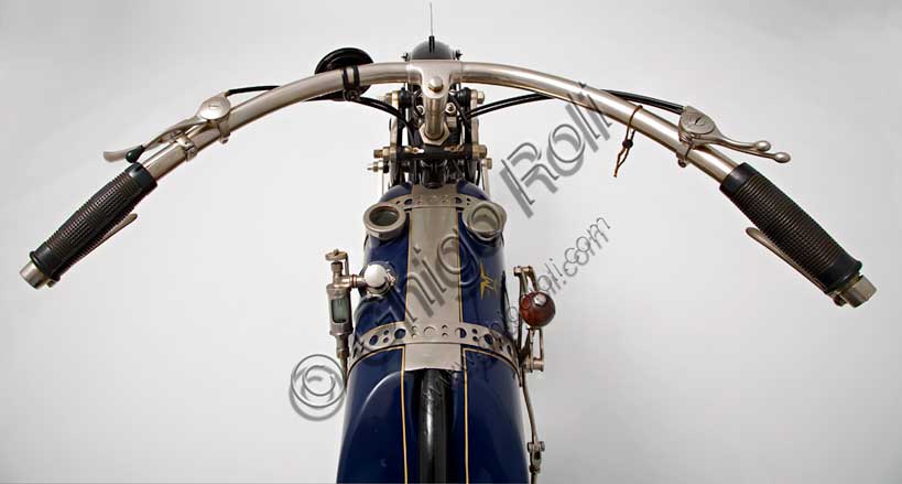 Moto d'epoca “Martinsyde 500 Sports” Marca: Martinsydemodello: 500 Sportsnazione: Regno Unito - Wokinganno: 1922condizioni: restauratacilindrata: 497,3 (alesaggio e corsa 60 x 88)motore: bicilindrico a V  i.o.e. (a valvole contrapposte, scarico in testa)cambio: AJS a tre rapportiFondata nel 1908 da Helmuth Paul Martin e George Harris Handasyde, la Martinsyde fu la terza azienda britannica per la produzione di aeroplani durante la Prima Guerra Mondiale. Alla fine della guerra, calato il bisogno di aerei, iniziò a produrre motociclette. Ma nel 1922 un disastroso incendio rase al suolo lo stabilimento e la Martinsyde fu liquidata.Nella sua breve storia la Martinsyde diede vita a un 350 monocilindrico, e a tre bicilindrici a valvole contrapposte, su progetto di Howard Newman: un 680 cc, un 740 cc e questo bellissimo Sports di 500. Di tutta la produzione sopravvivono solo 19 esemplari.