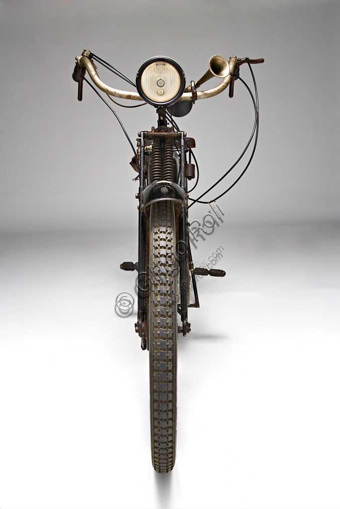 Moto d'epoca Mignon 125 N.Marca: Moto Mignon Modena (MMM)modello: 125 Tipo Normalenazione: Italia - Modenaanno: 1925condizioni: conservatacilindrata: 123,6 (alesaggio e corsa 54 x 54)motore: monocilindrico a valvole contrapposte: aspirazione in testa, scarico lateralecambio: in blocco a due rapportiVittorio Guerzoni, dopo un tirocinio a Torino nell' industria automobilistica dove, lavorando da operaio, si diploma meccanico, apre la sua officina a Modena nel dopoguerra. Costruisce il primo prototipo della sua bicicletta a motore nel '20, con motore progettato da Armando Caiumi. Più tardi costruirà moto più potenti di 175, 250 e 500 cc, anche nella versione Corsa, alcune delle quali furono utilizzate dalla scuderia Ferrari. Dopo il '33 non compare più il marchio Mignon ma Guerzoni continua a costruire alcune moto con il suo nome (Moto Guerzoni - MG) e, soprattutto, i motori Taurus per conto del Cav. Fabbri di Milano.