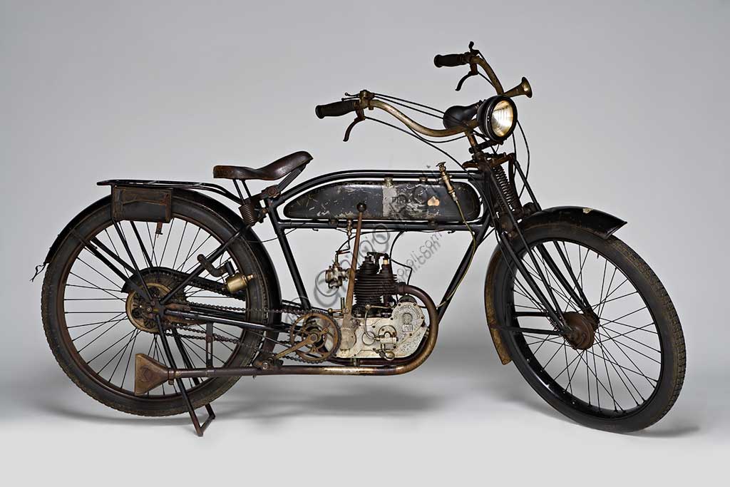 Moto d'epoca Mignon 125 N.Marca: Moto Mignon Modena (MMM)modello: 125 Tipo Normalenazione: Italia - Modenaanno: 1925condizioni: conservatacilindrata: 123,6 (alesaggio e corsa 54 x 54)motore: monocilindrico a valvole contrapposte: aspirazione in testa, scarico lateralecambio: in blocco a due rapportiVittorio Guerzoni, dopo un tirocinio a Torino nell' industria automobilistica dove, lavorando da operaio, si diploma meccanico, apre la sua officina a Modena nel dopoguerra. Costruisce il primo prototipo della sua bicicletta a motore nel '20, con motore progettato da Armando Caiumi. Più tardi costruirà moto più potenti di 175, 250 e 500 cc, anche nella versione Corsa, alcune delle quali furono utilizzate dalla scuderia Ferrari. Dopo il '33 non compare più il marchio Mignon ma Guerzoni continua a costruire alcune moto con il suo nome (Moto Guerzoni - MG) e, soprattutto, i motori Taurus per conto del Cav. Fabbri di Milano.