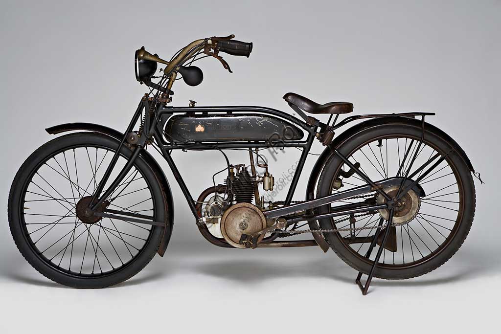 Moto d'epoca Mignon 125 N.Marca: Moto Mignon Modena (MMM)modello: 125 Tipo Normalenazione: Italia - Modenaanno: 1925condizioni: conservatacilindrata: 123,6 (alesaggio e corsa 54 x 54)motore: monocilindrico a valvole contrapposte: aspirazione in testa, scarico lateralecambio: in blocco a due rapportiVittorio Guerzoni, dopo un tirocinio a Torino nell' industria automobilistica dove, lavorando da operaio, si diploma meccanico, apre la sua officina a Modena nel dopoguerra. Costruisce il primo prototipo della sua bicicletta a motore nel '20, con motore progettato da Armando Caiumi. Più tardi costruirà moto più potenti di 175, 250 e 500 cc, anche nella versione Corsa, alcune delle quali furono utilizzate dalla scuderia Ferrari. Dopo il '33 non compare più il marchio Mignon ma Guerzoni continua a costruire alcune moto con il suo nome (Moto Guerzoni - MG) e, soprattutto, i motori Taurus per conto del Cav. Fabbri di Milano.