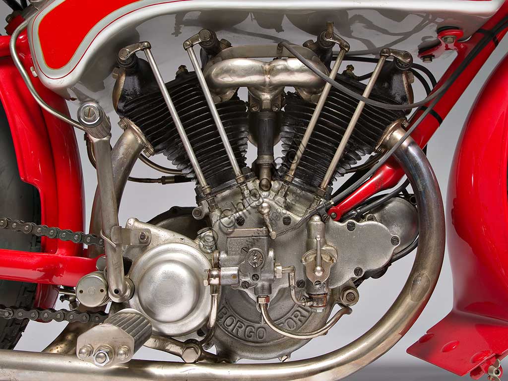 Moto d'epoca Motoborgo 500. Motore.fabbrica: Borgomodello: 500 fabbricata in: Italia - Torinoanno di costruzione: 1922condizioni: restauratacilindrata: 498 ccmotore: bicilindrico a V cambio: a due rapporti con frizione automaticaLa 500 bicilindrica, sicuramente una delle più belle moto degli anni '20, fu il canto del cigno della torinese Borgo, che dal '23 in avanti produrrà solo pistoni, fornendo, tra le altre aziende, anche la Ferrari. Con 20 Cv a 5500 giri (alesaggio x corsa:  68 x 68) raggiungeva facilmente i 120 Kmh, cosa che la fece apprezzare anche in ambito sportivo, dove raccolse numerosi successi. Unisce a soluzioni tecniche piuttosto rare, una notevole cura estetica, come nei particolari giunti sferici dei  semimanubri, che, realizzati in unica fusione con gli attacchi della forcella, consentono di variare l'assetto a piacere.Ha il serbatoio dell'olio ricavato nei tubi del telaio e un serbatoio dell'olio supplementare, sovrapposto a quello della benzina. All'avanguardia per i tempi, il cambio in blocco con il motore.