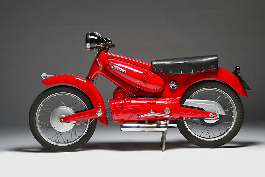 Moto d'epoca Motom 98 TSMarca: Motommodello: 98 TSnazione: Italia - Milanoanno: 1955condizioni: restauratacilindrata: 98 cc. (alesaggio e corsa 50 x 50)motore: monocilindrico a quattro tempicambio: in blocco a quattro rapportiPiù di altre case la Motom ha fatto del design un elemento fondamentale e costante della sua produzione. Pensato già in fase di elaborazione progettuale, per Motom è spesso lo stile, più che la necessità, a disegnare le forme. Questo modello fu affidato a Pietro Remor, già progettista delle quattro cilindri Gilera e MV. L'eleganza della linea che unisce forcella anteriore, tunnel centrale e forcellone posteriore nasconde alcune soluzioni tecniche di assoluta avanguardia come la forcella a barre di torsione che è infulcrata ad un trave tubolare nascosto dal parafango, o ancora Il telaio in lamiera stampata che pesa solo 6 kg e racchiude serbatoio e vano porta oggetti. Questo capolavoro assoluto del design industriale non fu capito. Ne vennero prodotte solo 1736 unità.