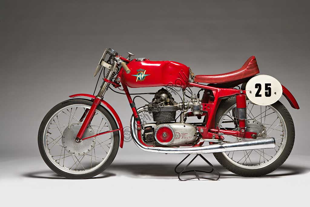 Moto d'epoca MV Agusta 125 Monoalbero CorsaMarca: MV Agustamodello: 125 Monoalbero Corsanazione: Italia - Schiranna (VA)anno: 1954condizioni: conservatacilindrata: 123,5 (alesaggio e corsa 53 x 56)motore: monocilindrico, albero a cammes in testacambio: a quattro rapportiLa storica azienda fondata nel 1907 dal Conte Giovanni Agusta, nota per la produzione aeronautica, iniziò a produrre motociclette con il figlio Domenico solo nel '46, con il nome Meccanica Verghera (MV). Dopo le prime 98, nelle versioni Turismo e Sport, costruisce moto sempre più orientate verso le competizioni; questo esemplare, che toccava i 150 km/h, ne è una delle prime testimonianze.E' appena il caso di ricordare che, la MV con  75 campionati del mondo e 270 Gran Premi vinti, è la marca più vittoriosa della storia del motociclismo. Un record nei record: con Giacomo Agostini, vinse ininterrottamente il campionato del mondo dal 1967 al 1973 sia nella classe 350 che nella 500.