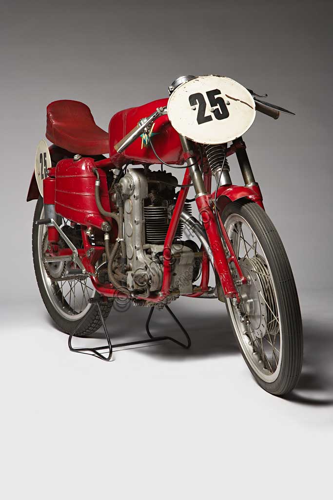 Moto d'epoca MV Agusta 125 Monoalbero CorsaMarca: MV Agustamodello: 125 Monoalbero Corsanazione: Italia - Schiranna (VA)anno: 1954condizioni: conservatacilindrata: 123,5 (alesaggio e corsa 53 x 56)motore: monocilindrico, albero a cammes in testacambio: a quattro rapportiLa storica azienda fondata nel 1907 dal Conte Giovanni Agusta, nota per la produzione aeronautica, iniziò a produrre motociclette con il figlio Domenico solo nel '46, con il nome Meccanica Verghera (MV). Dopo le prime 98, nelle versioni Turismo e Sport, costruisce moto sempre più orientate verso le competizioni; questo esemplare, che toccava i 150 km/h, ne è una delle prime testimonianze.E' appena il caso di ricordare che, la MV con  75 campionati del mondo e 270 Gran Premi vinti, è la marca più vittoriosa della storia del motociclismo. Un record nei record: con Giacomo Agostini, vinse ininterrottamente il campionato del mondo dal 1967 al 1973 sia nella classe 350 che nella 500.