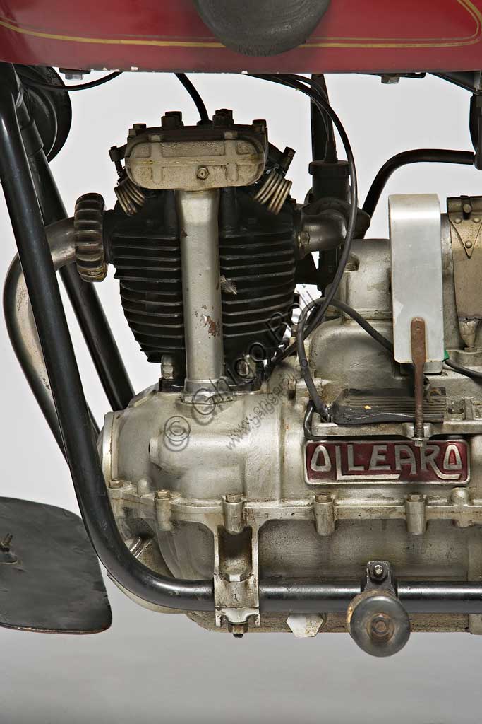 Moto d'epoca Ollearo Tipo Quattro 175. Motore.Marca: Ollearomodello: Tipo Quattro 175nazione: Italia - Torinoanno: 1932condizioni: restauratacilindrata: 175 (alesaggio e corsa 60 x 61,5)motore: Monocilindrico a quattro tempi e valvole in testacambio: in blocco, a quattro rapporti Neftali Ollearo apre l'attività di costruttore nel 1923 in Corso Valentino mettendo a punto una bicicletta a motore di 131 cc. e, in pochi anni, è già conosciuto per l'alta qualità e le raffinate soluzioni tecniche delle sue moto. Questa Tipo Quattro di 175 cc. ha, rara tra le moto italiane, trasmissione finale ad albero e giunti cardanici. Il cambio, novità per quegli anni, è già in un unico blocco con il motore. Monta freni a tamburo su ogni ruota.Costa, all'uscita nel 1930, 5900 Lire, ridotte a 4750 nel 1933. La pubblicità recita: "La prima moto e l'unica che accomuna stabilità, sicurezza e comodità, sin ora sconosciute"... L'azienda, con l'entrata in guerra dell'Italia e le conseguenti restrizioni alla circolazione, produrrà solo motofurgoni e motocarri. 