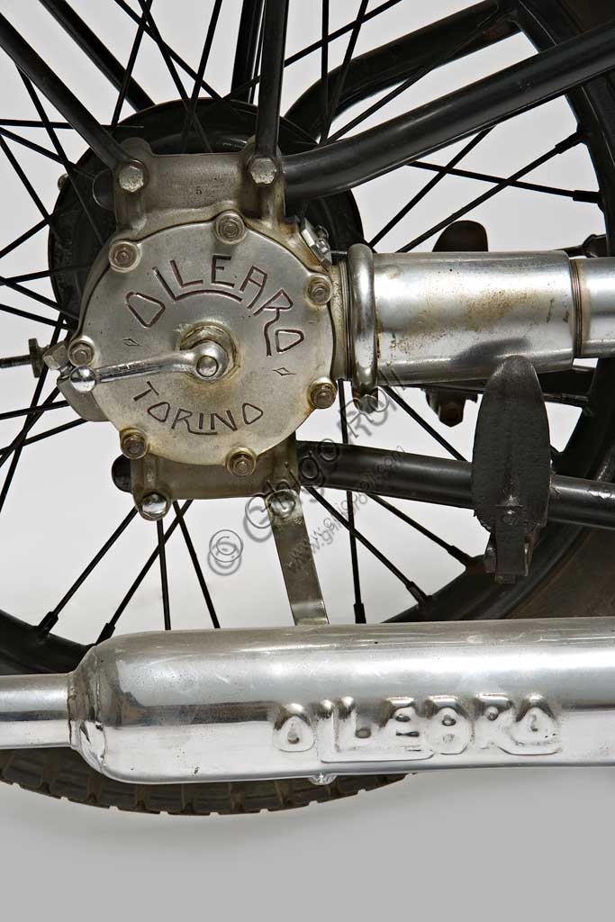 Moto d'epoca Ollearo Tipo Quattro 175. Ruota.Marca: Ollearomodello: Tipo Quattro 175nazione: Italia - Torinoanno: 1932condizioni: restauratacilindrata: 175 (alesaggio e corsa 60 x 61,5)motore: Monocilindrico a quattro tempi e valvole in testacambio: in blocco, a quattro rapporti Neftali Ollearo apre l'attività di costruttore nel 1923 in Corso Valentino mettendo a punto una bicicletta a motore di 131 cc. e, in pochi anni, è già conosciuto per l'alta qualità e le raffinate soluzioni tecniche delle sue moto. Questa Tipo Quattro di 175 cc. ha, rara tra le moto italiane, trasmissione finale ad albero e giunti cardanici. Il cambio, novità per quegli anni, è già in un unico blocco con il motore. Monta freni a tamburo su ogni ruota.Costa, all'uscita nel 1930, 5900 Lire, ridotte a 4750 nel 1933. La pubblicità recita: "La prima moto e l'unica che accomuna stabilità, sicurezza e comodità, sin ora sconosciute"... L'azienda, con l'entrata in guerra dell'Italia e le conseguenti restrizioni alla circolazione, produrrà solo motofurgoni e motocarri. 