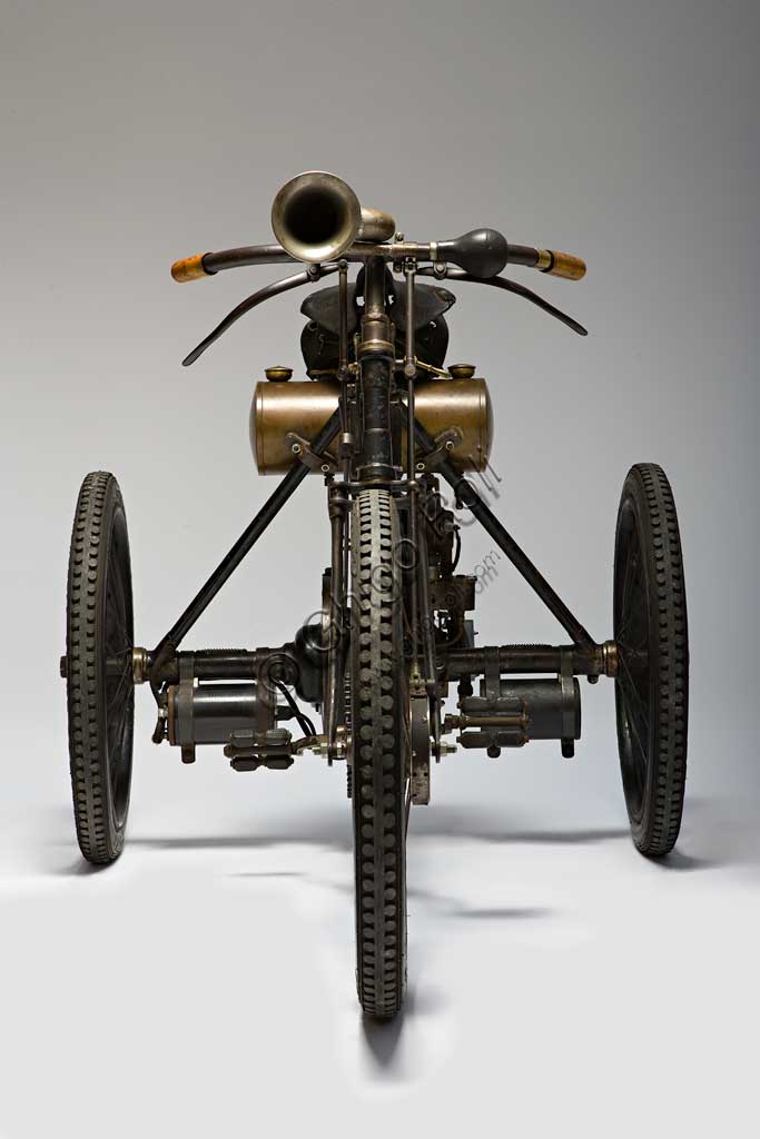 Moto d'epoca Perfecta Triciclo tipo Sport.Marca: Perfecta/ De Dion Boutonmodello: tipo Sportnazione: Italia - Torinoanno: 1898condizioni: restauratocilindrata: 240 ccmotore: Monocilindrico a valvole contrapposteaspirazione automatica in testa, scarico lateralecambio:trasmissione diretta a ingranaggi con differenzialeNell'epoca dei primi pionieri dell'era del motore figura la Perfecta di Bender & Martiny. Ha sede a Nole Canavese e si occupa in un primo tempo dell'assemblaggio di vetture con parti di provenienza francese e tedesca. Poi, dal 1898, inizia la costruzione di tricicli e quadricicli con motorizzazione Gaillardet o, come in questo caso, montando il collaudato monocilindrico De Dion-Bouton. In questi stessi anni, in Italia, tricicli simili e con la stessa motorizzazione De Dion-Bouton vengono fabbricati da Bianchi, Prinetti e Stucchi e altri. La ditta, dal 1903, produrrà solo automobili con il prestigioso marchio Invicta. Questo esemplare, che partecipò alla Parigi-Bordeaux, monta un carburatore a superficie, freno anteriore a nastro, e raggiunge ancor oggi i 45 km/h.