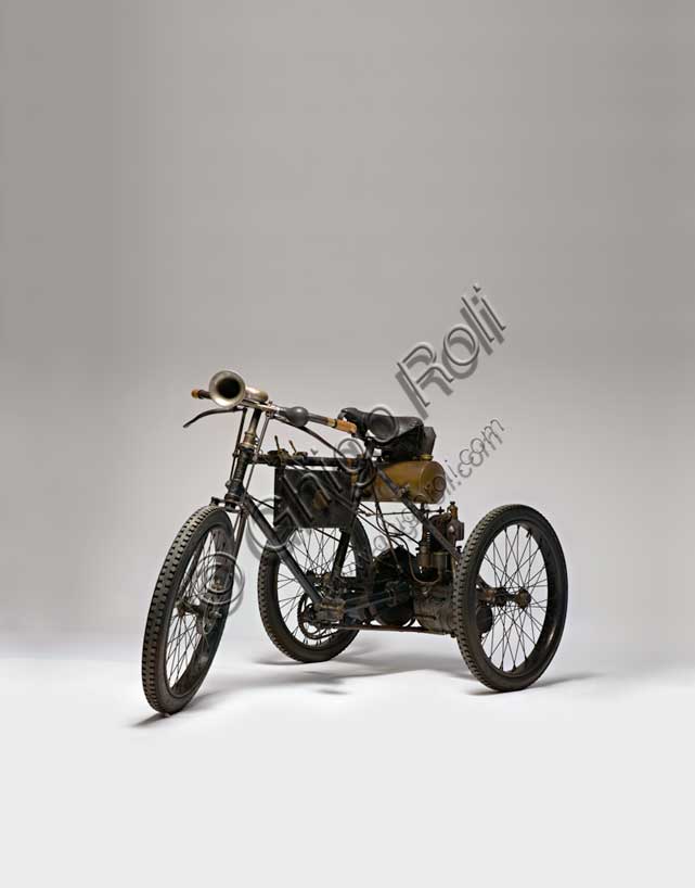Vintage motorcycle “Perfecta Triciclo tipo Sport”.Brand: Perfecta / De Dion Boutonmodel: Sport typecountry: Italy - Turinyear: 1898condition: restoreddisplacement: 240 ccengine: Single-cylinder with opposed valves with automatic overhead intake, side exhaustgearbox: direct transmission with gears with differentialIn the era of the first pioneers of the engine era, there is Perfecta by Bender & Martiny. It is based in Nole Canavese and initially deals with the assembly of cars with parts of French and German origin. Then, from 1898, it begins the construction of tricycles and quadricycles with Gaillardet engines or, as in this case, mounting the proven single-cylinder De Dion-Bouton. In these same years, in Italy, similar tricycles and with the same De Dion-Bouton engines are manufactured by Bianchi, Prinetti and Stucchi and others.