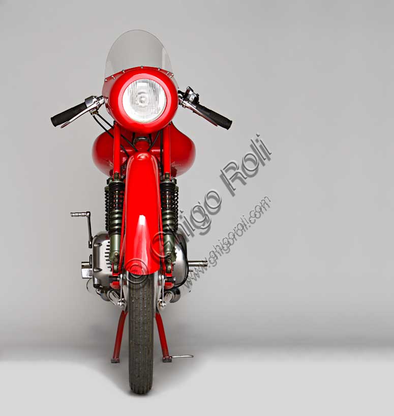 Moto d'epoca “Rumi Junior 125”Marca: Fonderie Officine Rumimodello: Junior 125nazione: Italia - Bergamoanno: 1956condizioni: restauratacilindrata: 124,6 (alesaggio e corsa 42 x 45)motore: bicilindrico orizzontale due tempicambio: in blocco a quattro rapportiDonnino Rumi subentra al padre nella fonderia per bronzo da questi creata. Durante la Seconda Guerra Mondiale rifiuta di convertire la produzione a scopi bellici e diventa partigiano latitante. Nel dopoguerra, alla domanda di mezzi di trasporto economici, risponde affiancando la produzione di motoleggere a quella già avviata di macchine tessili e per pastifici. Con l'aiuto dell'amico progettista nautico Pietro Vassena, nel 1949 è in grado di presentare al salone di Milano la prima, innovativa, motocicletta Rumi.La Junior deriva dalla "Bicarburatore" monta una forcella Earles, ed è fin dall'inizio destinata alle corse. Viene venduta a corridori privati sia italiani che stranieri e, grazie alla sua agilità, riscuote grande successo.