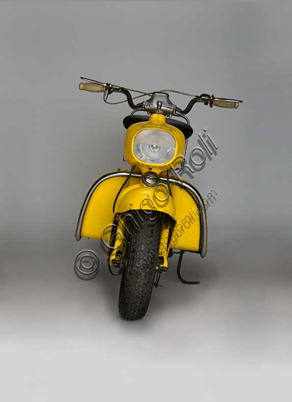 Vintage Motorcycle (Scooter) “Rumi Formichino”Brand: Fonderie Officine Rumimodel: Formichinocountry: Italy - Bergamoyear: 1955 - 6condition: restoreddisplacement: 124.6 (bore and stroke 42 x 45)engine: two-stroke horizontal twin-cylindergearbox: four-speed blockIn the wake of the success of the Vespa and Lambretta, Rumi felt the need to produce its own scooter. The mythology of the house's admirers has it that the absolutely unique shape of the Formichino was shaped directly in clay by Donnino Rumi after having fixed the engine on two stands. In fact, the load-bearing body of this gigantic mechanical insect is cast in aluminum alloy in just two parts: the front one incorporates the tank, fork and headlight, the rear one everything else. It also had some success in competitions, winning the twenty-ninth Bol d'Or, which was followed by a small run of Formichinis with this name. From 1958, production was licensed