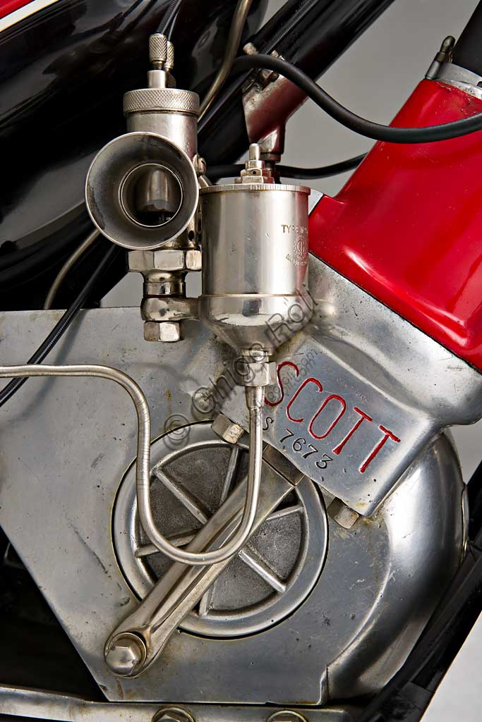 Moto d'epoca Scott Super Squirrel.Marca: Scottmodello: Super Squirrelnazione: Regno Unito - Shipleyanno: 1926 (?)condizioni: restauratacilindrata: 596motore: bicilindrico a due tempi raffreddato ad acquacambio: a due marceFondata a Shipley, nello Yorkshire, da Alfred Angus Scott, ideatore di più di cinquanta brevetti, la fabbrica Scott produsse motociclette dal 1909 fino al 1933. Nella produzione di serie vennero adottate diverse soluzioni particolarmente innovative. La Scott fu la prima moto ad adottare il raffreddamento ad acqua. Alcune scelte costruttive come il telaio a triangolo aperto, consentendo l’utilizzo del mezzo ad un pubblico femminile, sembravano indicare la volontà di rivolgersi ad una utenza “tranquilla”. Nonostante questo la Scott si rivelò presto una motocicletta veloce ed efficace, raccogliendo numerosi successi sportivi. Raggiungeva i 105 km/h. Vinse il Tourist Trophy. nel 1912 e nel 1913.