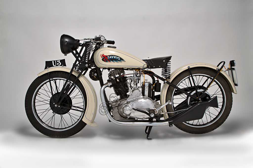 Moto d'epoca Taurus 175Marca: Taurus modello: 175 U3nazione: Italia - Milano e Modenaanno: 1934condizioni: restauratacilindrata: 169 (alesaggio e corsa 58 x 64) motore: monocilindrico inclinato in avanti di 20°, a valvole in testa, con scarico sdoppiatocambio: in semiblocco a tre rapportiLa ditta Fabbri inizia a Pavia, nel 1908, una attività di rappresentanza e importazione delle biciclette prodotte a Norimberga dalla Taurus Werke A.G.. Si trasferisce poi a Milano dove, dopo il 1930 inizia la commercializzazione di motociclette di proprio progetto, con il marchio Taurus, i cui propulsori sono fabbricati a Modena da Vittorio Guerzoni (Si veda la scheda della Mignon a pag.152 - 3).Nel 1933 compare la prima U3, della quale oggi sopravvivono pochissimi esemplari, moto assai elegante, disponibile nell'unica colorazione nero e avorio, e dalla tecnica ineccepibile.A partire dal 1938 anche la direzione commerciale si sposta a Modena da Guerzoni che, pur avendo sempre prodotto le moto non era mai comparso ufficialmente. Dal '39 la produzione verrà commercializzata col marchio M.G. Taurus.