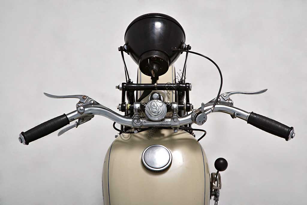 Moto d'epoca Taurus 175Marca: Taurus modello: 175 U3nazione: Italia - Milano e Modenaanno: 1934condizioni: restauratacilindrata: 169 (alesaggio e corsa 58 x 64) motore: monocilindrico inclinato in avanti di 20°, a valvole in testa, con scarico sdoppiatocambio: in semiblocco a tre rapportiLa ditta Fabbri inizia a Pavia, nel 1908, una attività di rappresentanza e importazione delle biciclette prodotte a Norimberga dalla Taurus Werke A.G.. Si trasferisce poi a Milano dove, dopo il 1930 inizia la commercializzazione di motociclette di proprio progetto, con il marchio Taurus, i cui propulsori sono fabbricati a Modena da Vittorio Guerzoni (Si veda la scheda della Mignon a pag.152 - 3).Nel 1933 compare la prima U3, della quale oggi sopravvivono pochissimi esemplari, moto assai elegante, disponibile nell'unica colorazione nero e avorio, e dalla tecnica ineccepibile.A partire dal 1938 anche la direzione commerciale si sposta a Modena da Guerzoni che, pur avendo sempre prodotto le moto non era mai comparso ufficialmente. Dal '39 la produzione verrà commercializzata col marchio M.G. Taurus.