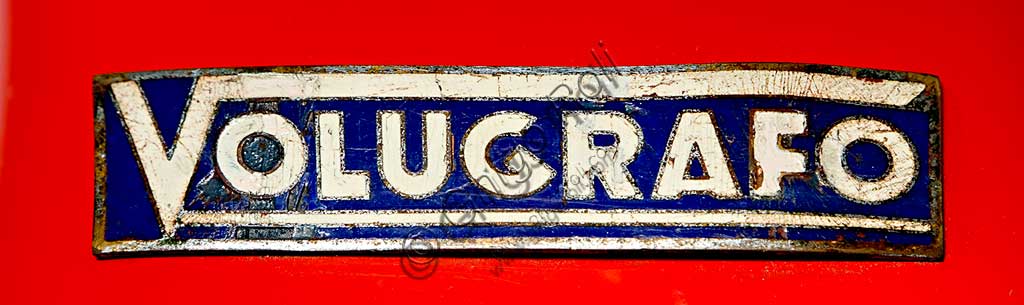 Moto d'epoca Volugrafo. Scooter. Marchio.Marca: Volugrafonazione: Italia - Torinoanno: 1939 (telaio N° 0/005)condizioni: restauratocilindrata: 98 cc.motore: Sachs a due tempicambio: L'ingegegnere torinese Vittorio Belmondo, progettò questo piccolo motopàttino verso il 1938. Questo mezzo, che ha scocca in lamiera stampata in unico pezzo e si ispira ai primi scooter americani, fu presentato nelle fiere di Torino e Milano nel 1940, ma, con lo scoppio della guerra, non entrò mai in produzione. La sua breve vita tuttavia non fu inutile: con ogni probabilità è proprio vedendone un esemplare a Biella, dove si erano rifugiati per sfuggire ai bombardamenti, che i tecnici della Piaggio elaborarono per la prima volta l'idea del Paperino, il babbo della Vespa.