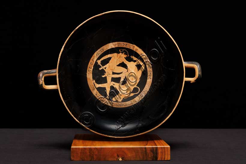 Museo Civico Archeologico di Bologna: Kylix attica a figure rosse con imprese dell’eroe Teseo. Opera di una delle maggiori personalità della ceramografia attica a figure rosse, questa coppa illustra alcune delle imprese compiute dall'eroe Teseo. Nel tondo centrale, all'interno, Teseo lotta con il Minotauro, il mostro metà uomo e metà toro, custode del labirinto di Minosse a Creta.Inventario G_0818
