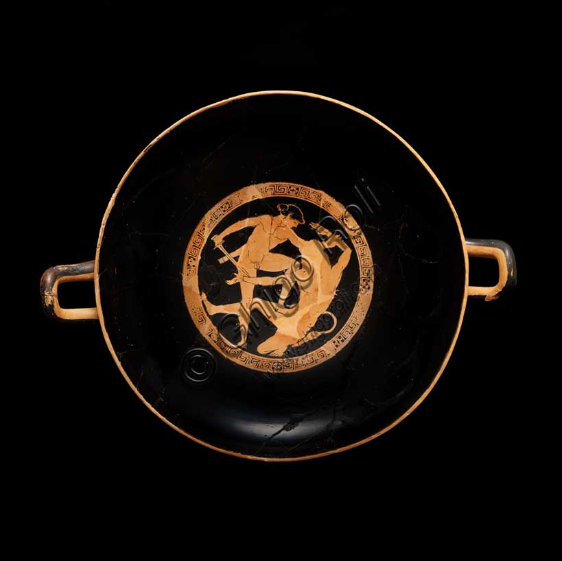Museo Civico Archeologico di Bologna: Kylix attica a figure rosse con imprese dell’eroe Teseo. Opera di una delle maggiori personalità della ceramografia attica a figure rosse, questa coppa illustra alcune delle imprese compiute dall'eroe Teseo. Nel tondo centrale, all'interno, Teseo lotta con il Minotauro, il mostro metà uomo e metà toro, custode del labirinto di Minosse a Creta.Inventario G_0818