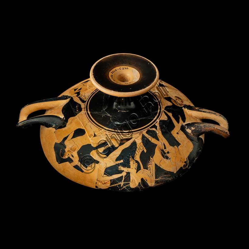 Museo Civico Archeologico di Bologna: Kylix attica a figure rosse con imprese dell’eroe Teseo. Opera di una delle maggiori personalità della ceramografia attica a figure rosse, questa coppa illustra alcune delle imprese compiute dall'eroe Teseo. All'esterno si susseguono quattro altre imprese dell'eroe, sapientemente disposte ed alternate a coprire, in una composizione equilibrata, l'intera parete del vaso. Teseo lotta con Kerkyon, con il gigante Prokrustes, doma il toro di Maratona e uccide, precipitandolo da una roccia, l'eroe megarese Skyron. La fortuna incontrata da Teseo nelle produzione a figure rosse è direttamente legata alle vicende politiche della città di Atene, che promuove un eroe squisitamente attico, protagonista di una serie di imprese, spesso scelte a paradigma del ruolo rivestito dalla città nelle vicende della Grecia.Inventario G_0818