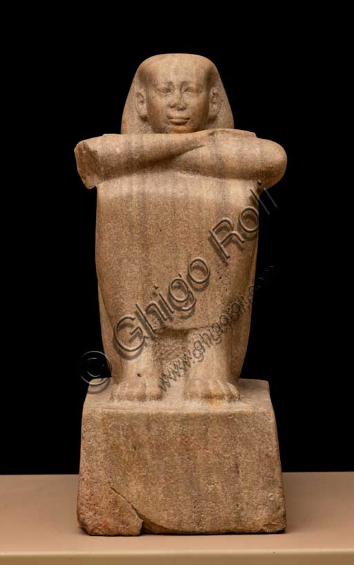 Museo Civico Archeologico di Bologna: statua cubo che rappresenta un uomo non identificato.La scultura, che riproduce un uomo seduto a terra con le ginocchia avvicinate al petto e con il corpo avvolto in una lunga veste dalla quale fuoriescono solo i piedi, le mani e la testa, appartiene alla tipologia delle statue-cubo a destinazione templare. Inventario EG 1824: alabastro; Epoca Tarda: XXVI dinastia, regno di Psammetico I (ca. 664-630 a.C.) (?)