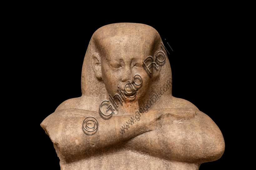 Museo Civico Archeologico di Bologna: statua cubo che rappresenta un uomo non identificato.La scultura, che riproduce un uomo seduto a terra con le ginocchia avvicinate al petto e con il corpo avvolto in una lunga veste dalla quale fuoriescono solo i piedi, le mani e la testa, appartiene alla tipologia delle statue-cubo a destinazione templare. Inventario EG 1824: alabastro; Epoca Tarda: XXVI dinastia, regno di Psammetico I (ca. 664-630 a.C.) (?)Particolare.