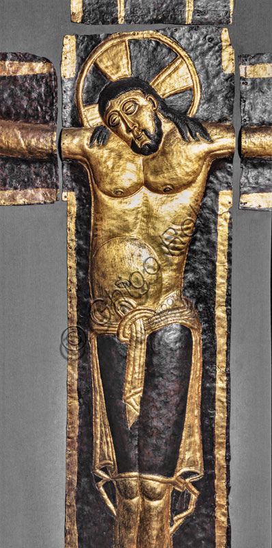  Museum of the Cathedral: the Ariberto's crucifix. The large embossed crucifix in copper foil and gilded brass is a masterpiece of late Ottoman metallics. It was built by the Bishop of the Carroccio, Ariberto da Intimiano, in 1040 ca. as an ornament of the place he had chosen for his burial, at the monastery of San Dionigi. Detail.