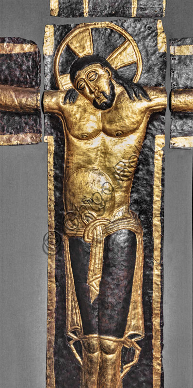 Museo del Duomo: il crocifisso di Ariberto. Il grande crocifisso a sbalzo in lamina di rame e di ottone dorata è un capolavoro di metallistica tardo-ottomana. Fu fatto realizzare dal Vescovo del Carroccio, Ariberto da Intimiano, nel 1040 ca. come ornamento del luogo che aveva prescelto per la sua sepoltura, presso il monastero di San Dionigi. Particolare.