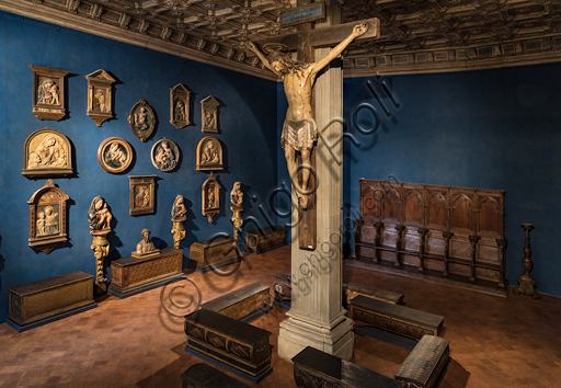 Museo Stefano Bardini: la sala dei rilievi di Madonna con Bambino e, al centro, il Crocifisso in legno policromo del XV secolo.